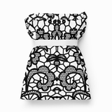 A black and white lace-patterned tote bag folded with a strap, displayed on a clean white background.