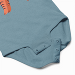 Blue baby romper with button details on a white background