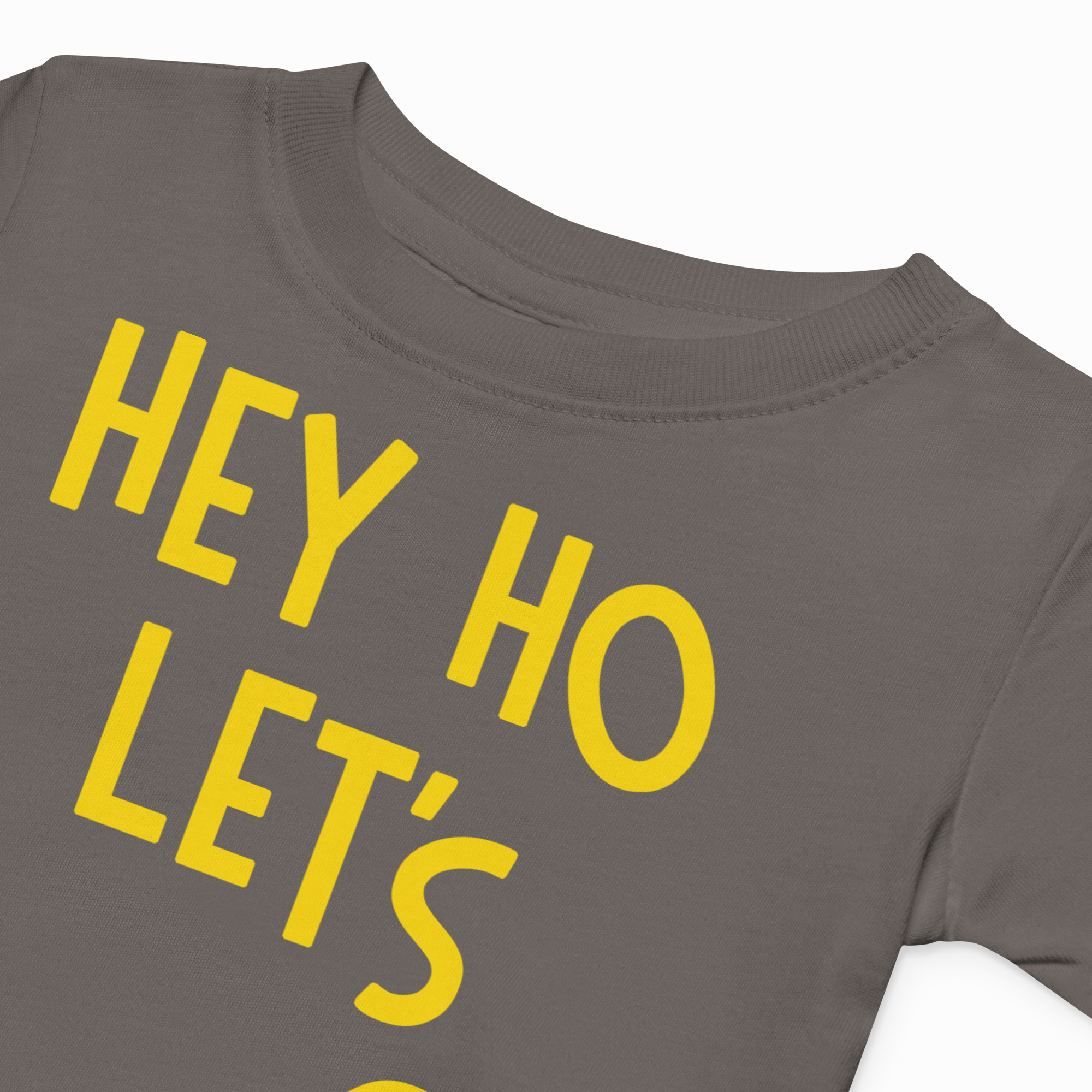Gray t-shirt with yellow text 'HEY HO LET'S' on a white background