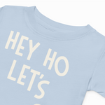Light blue t-shirt with 'HEY HO LET'S' text in white on a white background