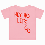 Pink t-shirt with red text 'HEY HO LET'S GO' on a white background