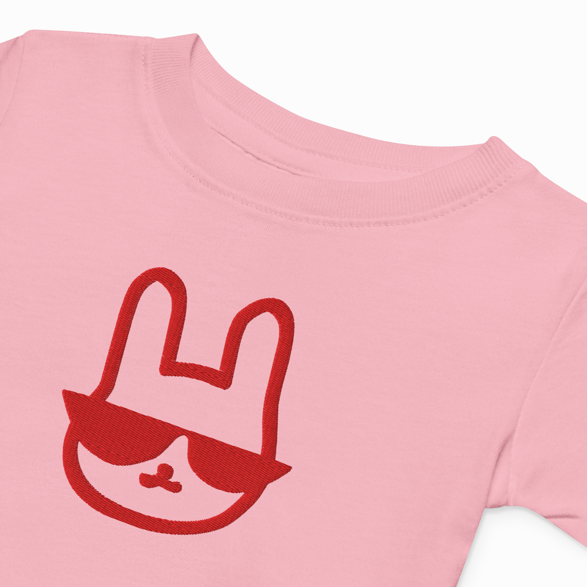 Pink t-shirt with a red graphic of a face with sunglasses on a white background