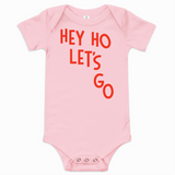 Pink baby onesie with red text 'HEY HO LET'S GO' on a white background