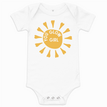 White baby onesie with yellow sun design and 'Glow Girl' text on a white background