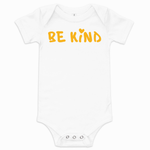 White baby short-sleeve one-piece bodysuit with yellow hand-lettered "Be Kind" graphic and small heart above the "i" on the front.