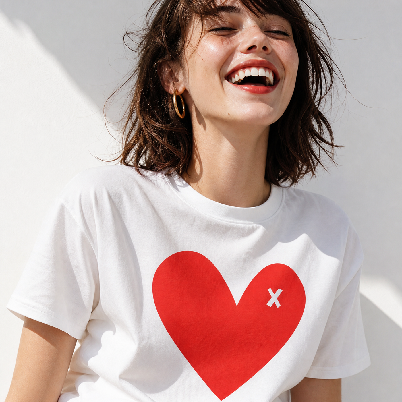 Woman wearing a white t-shirt with a red heart design on a light background