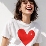 Woman wearing a white t-shirt with a red heart design on a light background