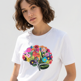 Person wearing a white t-shirt with a colorful floral design on a plain background