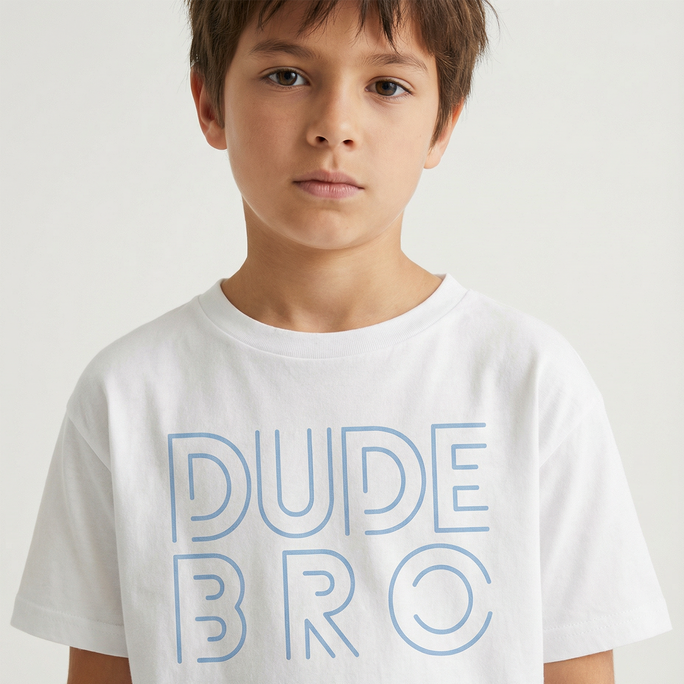 Child wearing a white t-shirt with 'DUDE BRO' text in blue on a plain background