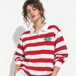Woman wearing an oversized red-and-white striped rugby shirt with white collar, styled with jeans.