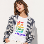 Person wearing a white t-shirt with colorful text and a striped jacket on a light background