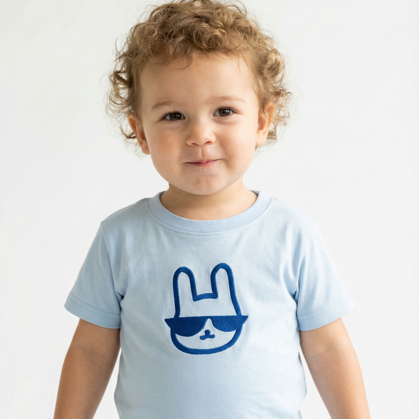 Child wearing a light blue t-shirt with a blue graphic on a white background
