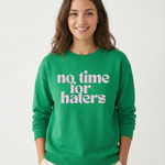 Person wearing a green sweatshirt with 'no time for haters' text on a white background