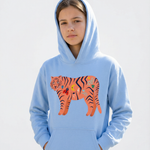 Person wearing a light blue hoodie with a tiger design on a white background