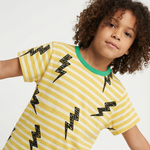 Child wearing a yellow and white striped shirt with black lightning bolt patterns on a plain background