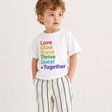 Child wearing a white t-shirt with colorful text on a plain background