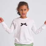 Child wearing a white long-sleeve shirt with a black bow design on a light gray background