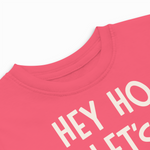 Close-up of a pink shirt with white text on a white background