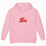 A light pink children's pullover hoodie with the words 'NOT SORRY' printed in red across the chest, shown against a plain white background.