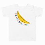 A white short-sleeve crewneck t-shirt featuring a graphic of a yellow banana with the text 'CICKOO BANANAS' written in colorful, playful lettering.