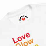 Close-up of a white crewneck t-shirt showing the inner neck label with 'chatter pop' and a red heart, and the colorful text 'Love Glow' printed on the front.