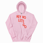 Pink hoodie with 'HEY HO LET'S GO' text in red on a white background