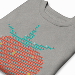 Angled close-up of a heather gray sweatshirt showing cross-stitch strawberry graphic detail with red and teal stitches.