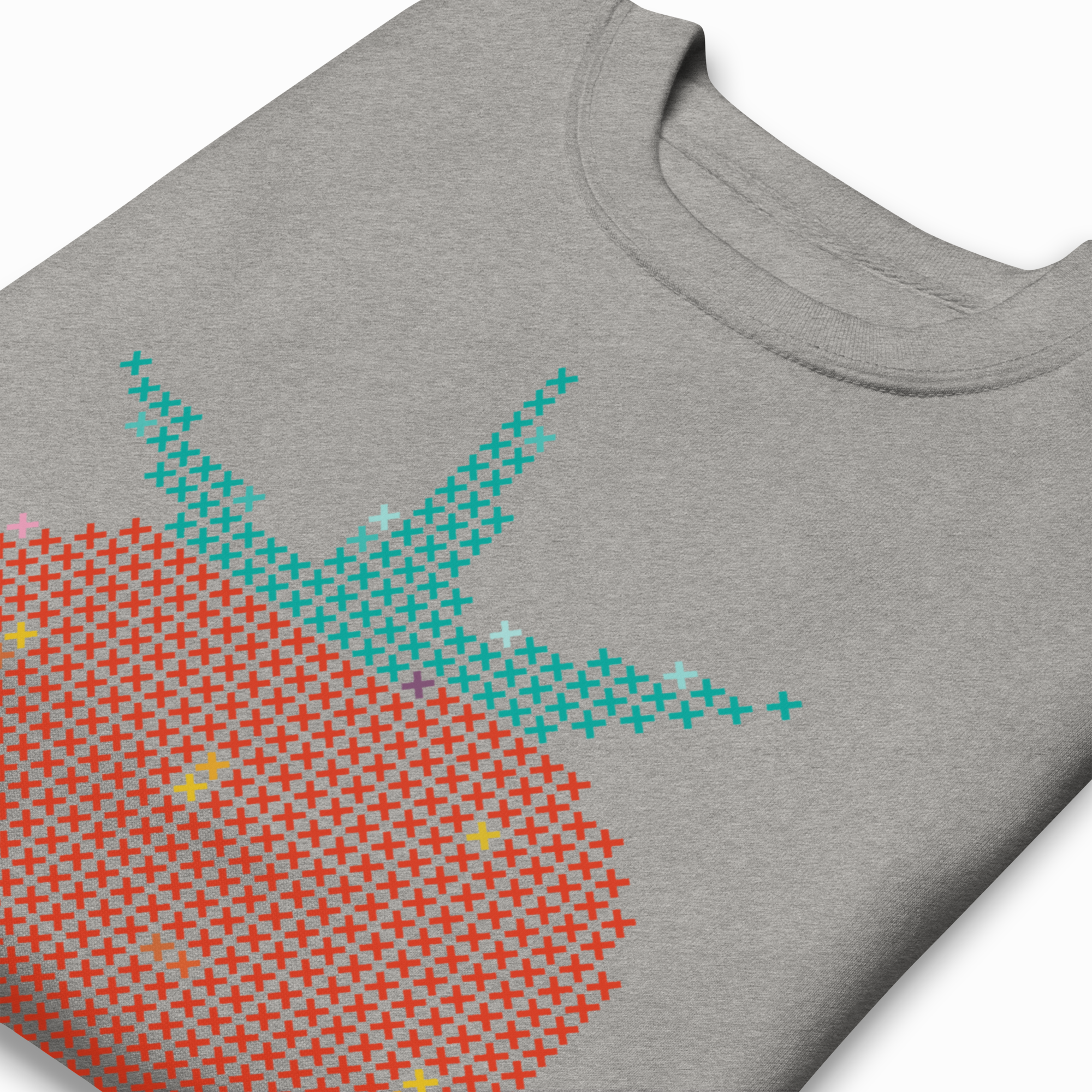 Angled close-up of a heather gray sweatshirt showing cross-stitch strawberry graphic detail with red and teal stitches.