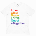 A white short-sleeve crewneck t-shirt featuring a stacked rainbow text graphic on the front that reads 'Love Glow Brave Thrive Quest + Together'.