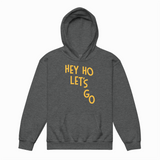 Gray hoodie with yellow text 'HEY HO LET'S GO' on a white background